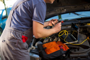 Mechanic working under hood of car